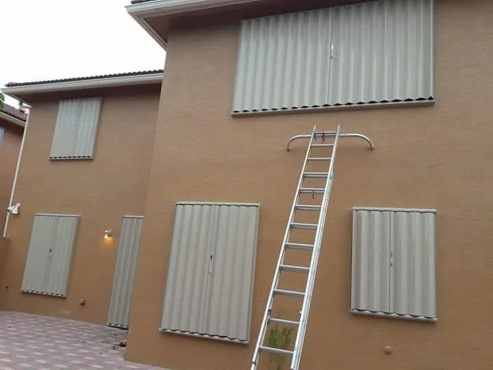Hurricane accordion shutters closed over the windows of a two-story home