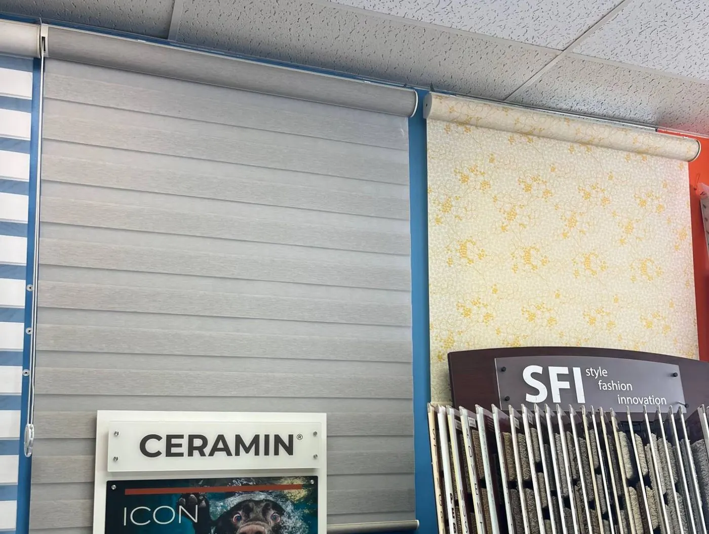 Gray zebra shade and patterned roller shade on display in the showroom